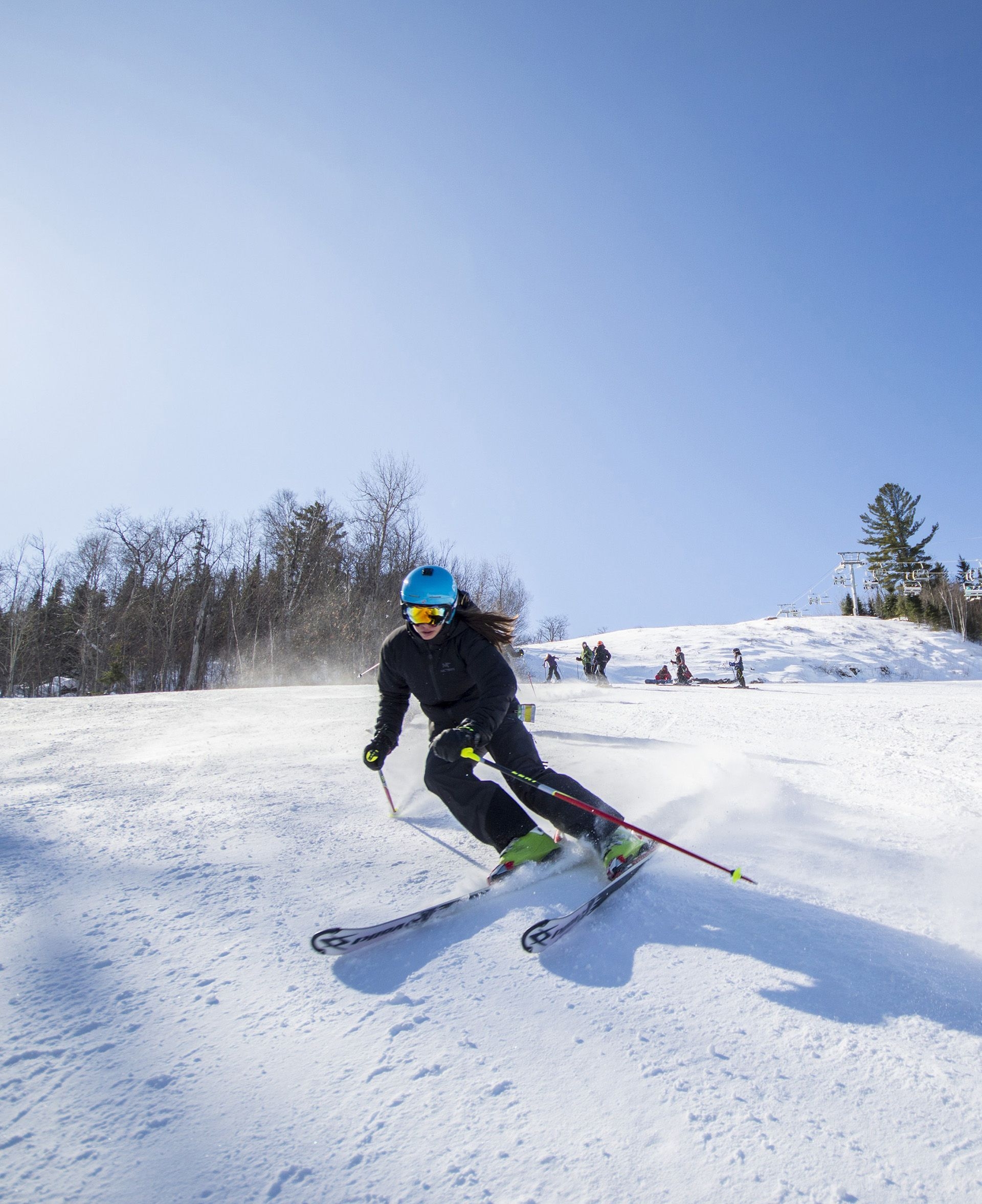 A young woman is downhill skiing.