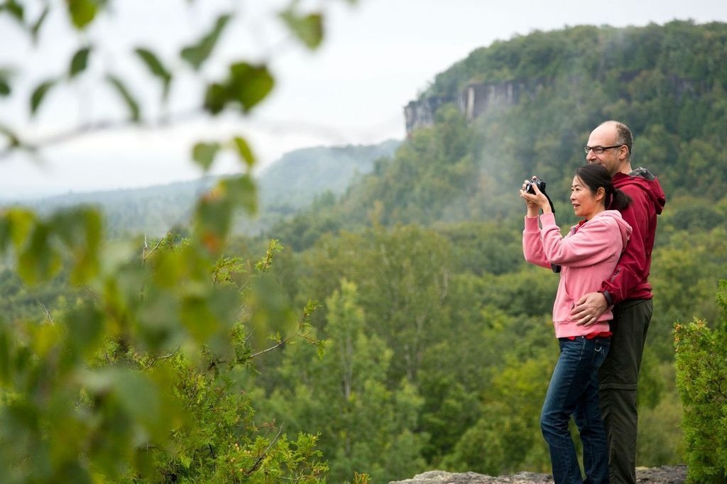A couple takes a photo of the view from the Cup and Saucer trail 