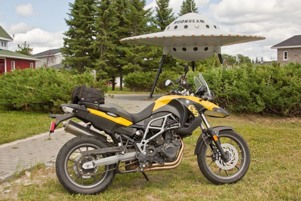 A yellow motorcycle is parked in front of the UFO in Moonbeam.