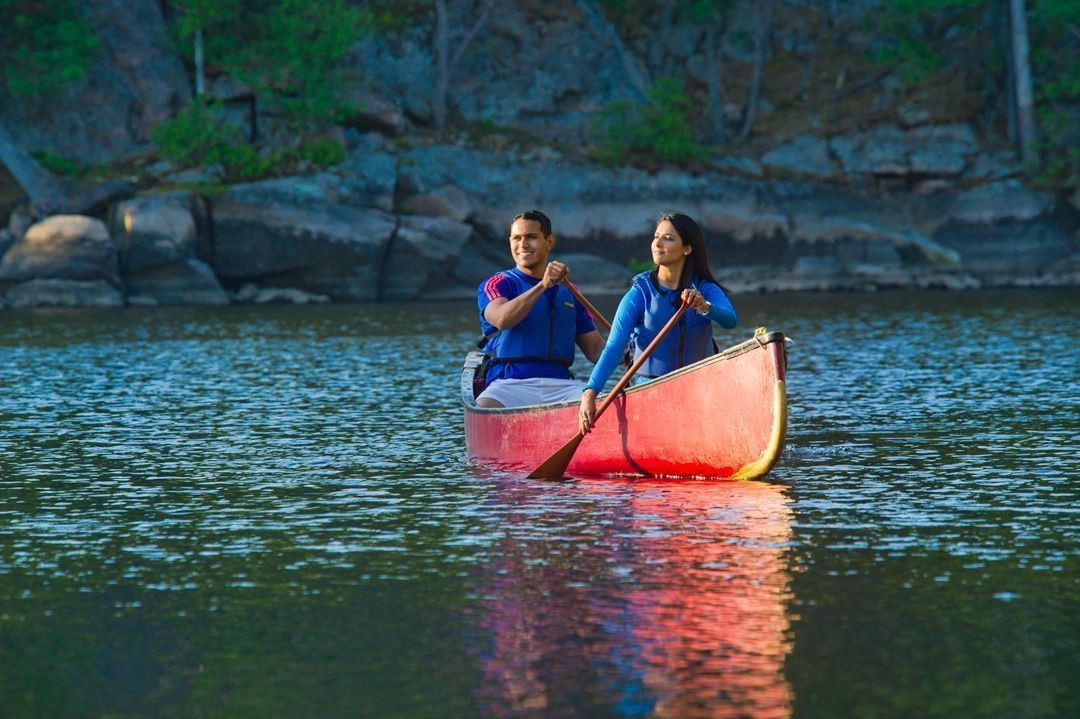 Two people paddle a red canoe on the french river.