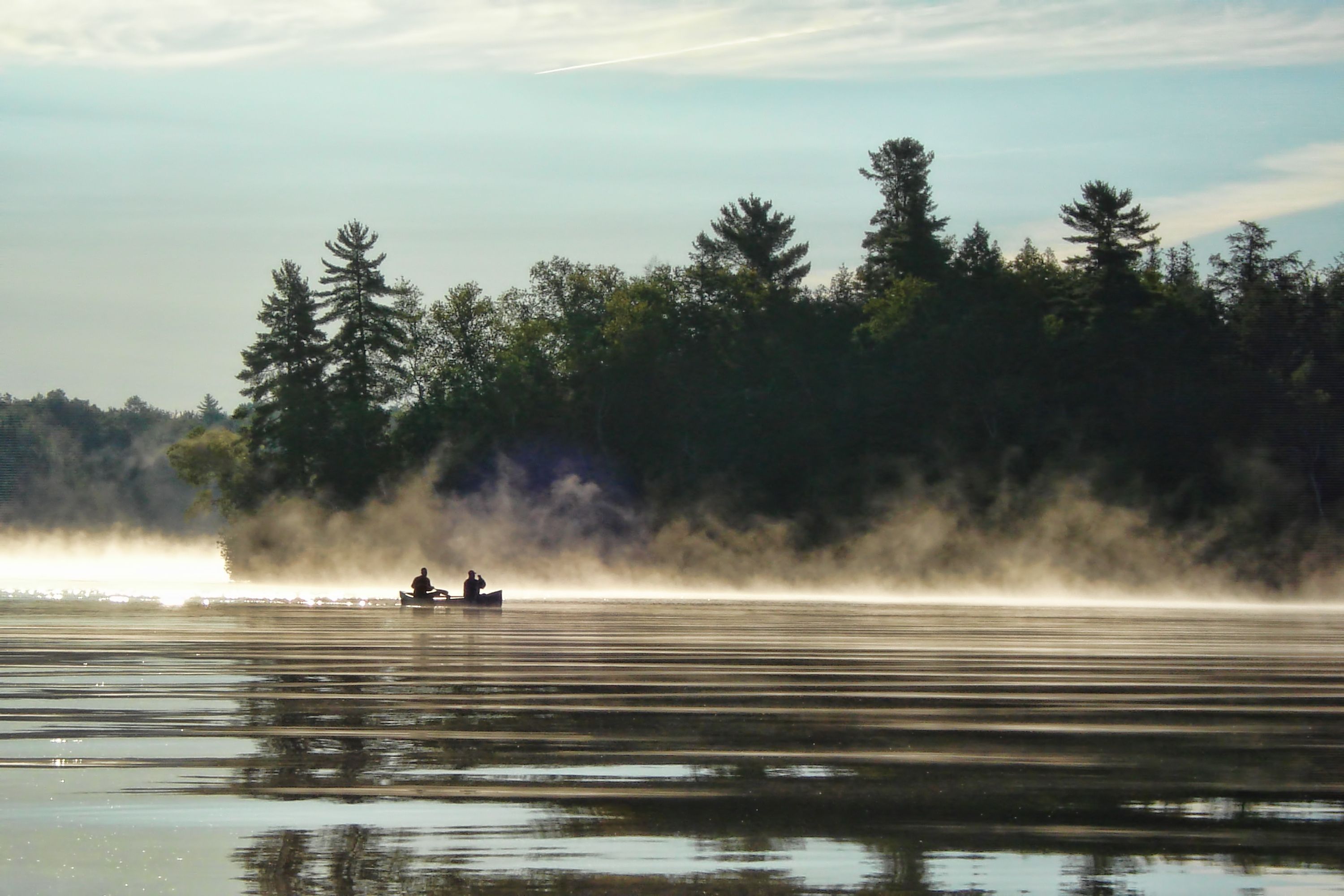 two people canoeing on a misty lake