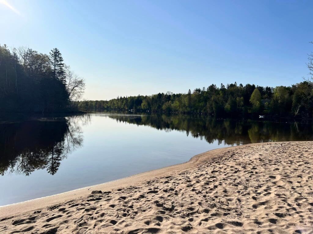 Une plage piétinée se dresse à l'embouchure de la rivière.
