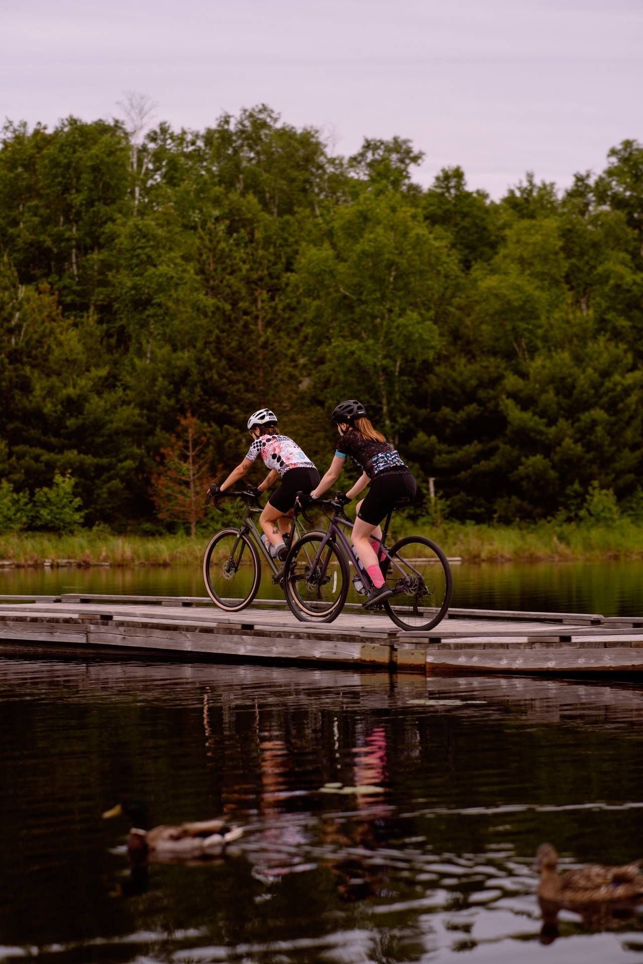 Two people biking across a boardwalk in Sudbury