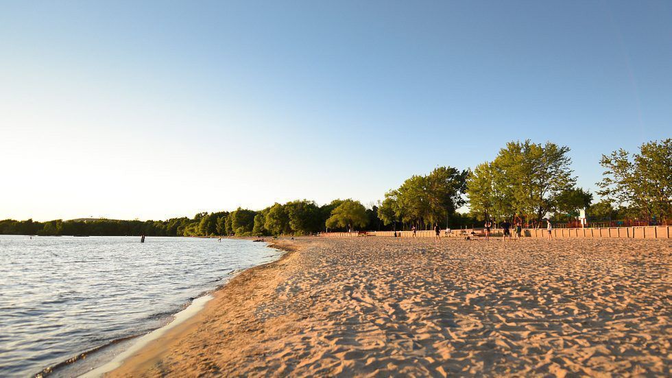 La plage de sable Marathon du lac Nipissing est bordée de grands arbres.
