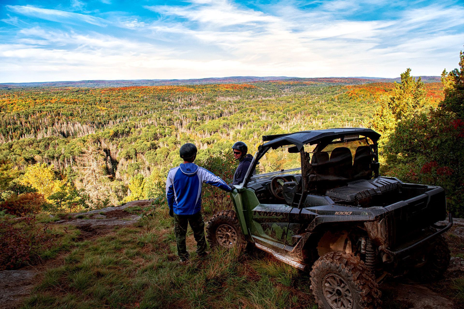 Two people stand next to their ATV at a lookout near Mattawa.