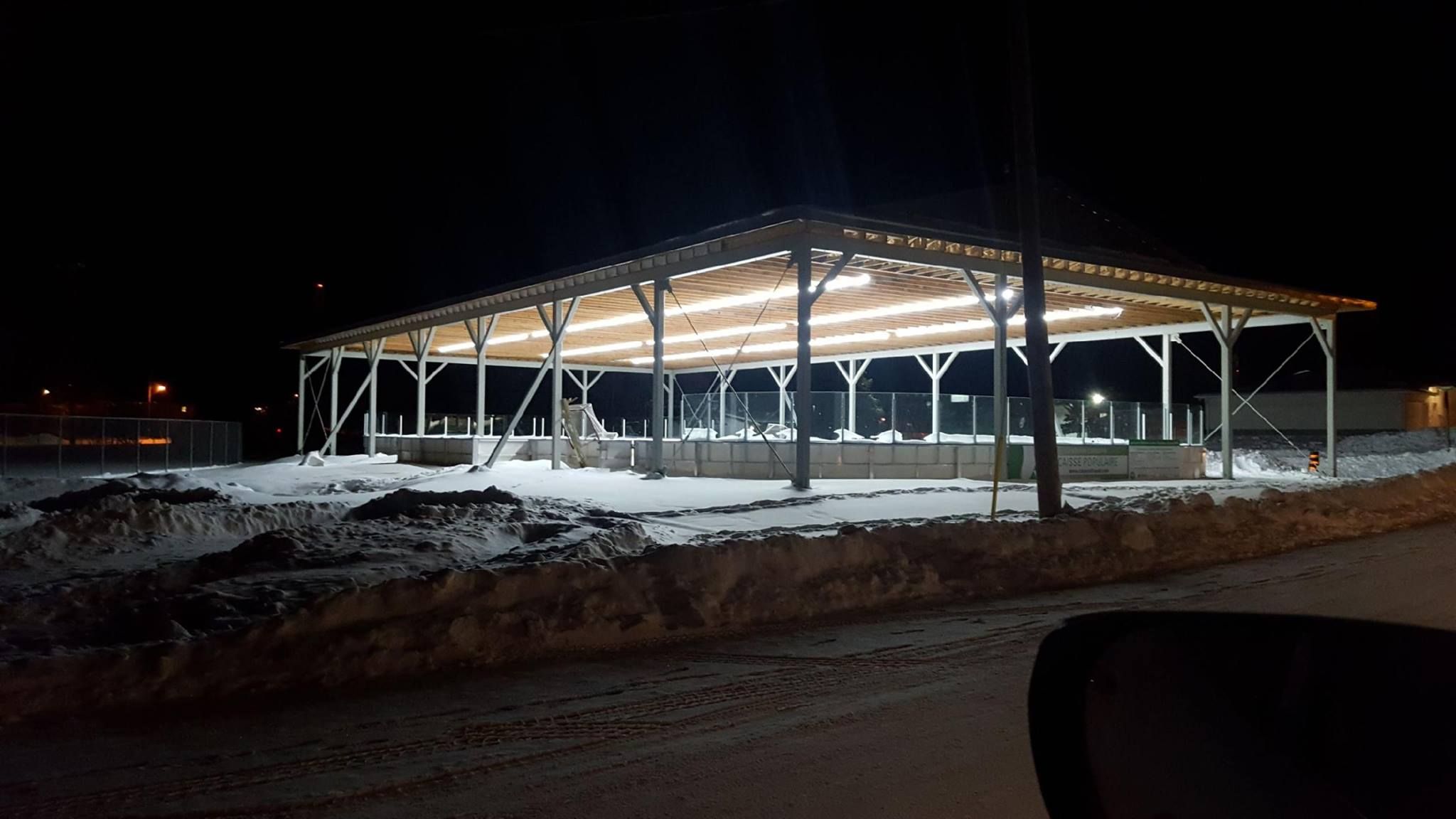An outdoor ice rink lit up with bright lights at night